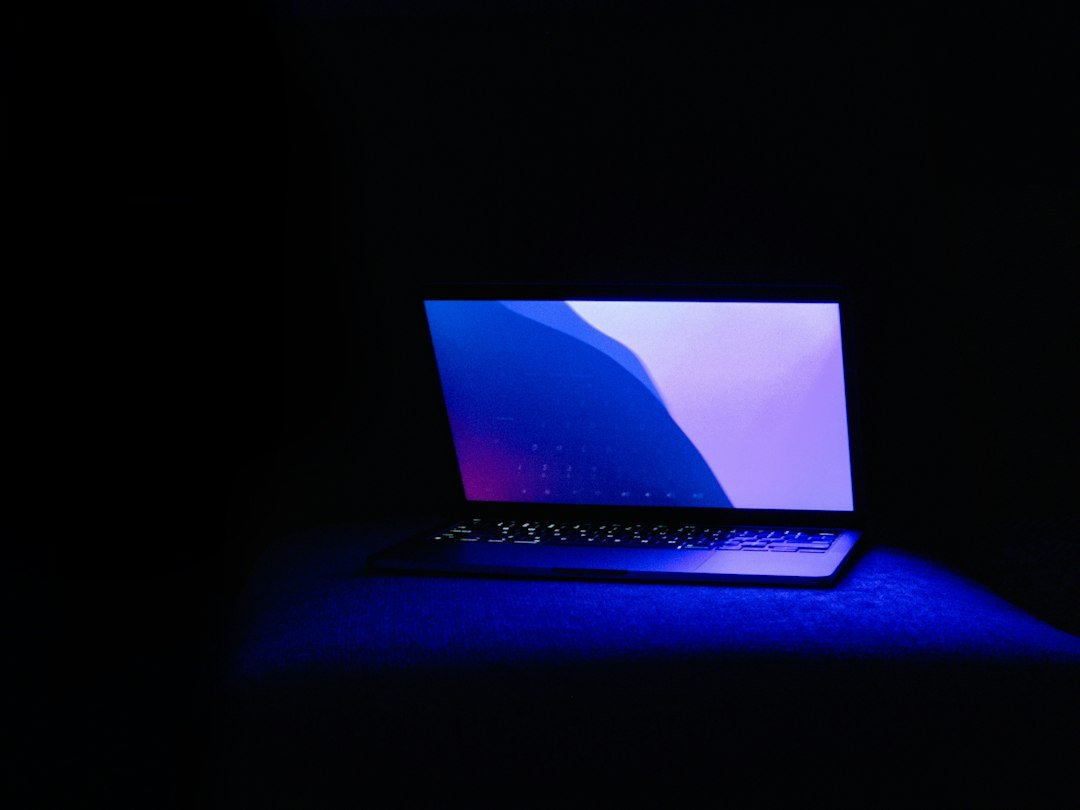 Ordinateur éclairé en bleu représentant un environnement numérique et les outils d'intelligence artificielle