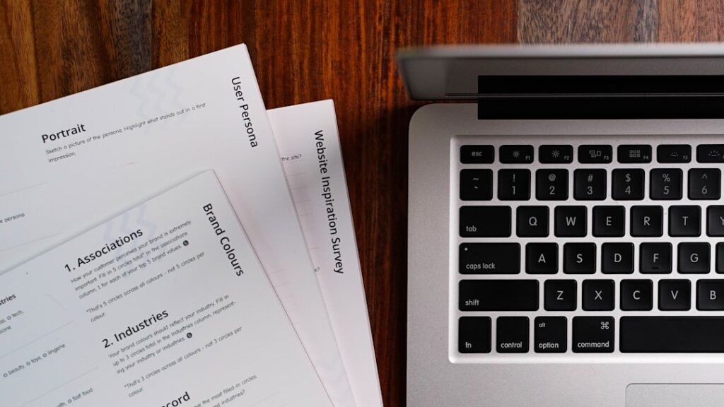 Ordinateur et documents sur un bureau pour illustrer la recherche et la vérification des sources